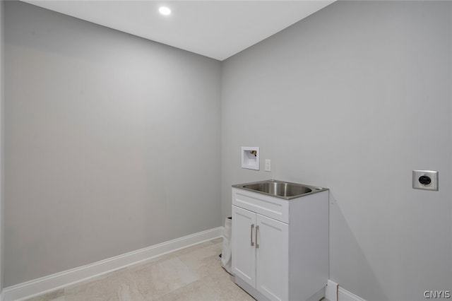 washroom with sink, electric dryer hookup, washer hookup, cabinets, and light tile flooring