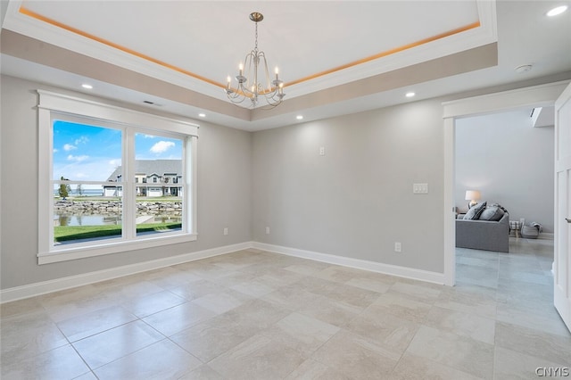 tiled spare room with a raised ceiling and a chandelier