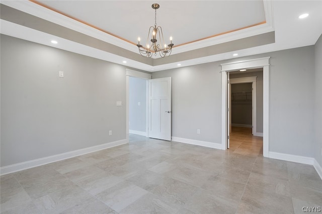 empty room featuring light tile floors, a raised ceiling, a notable chandelier, and crown molding