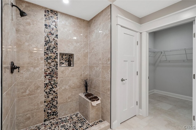 bathroom with tiled shower and tile flooring