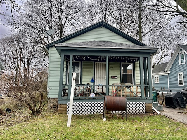 bungalow featuring a front yard and covered porch