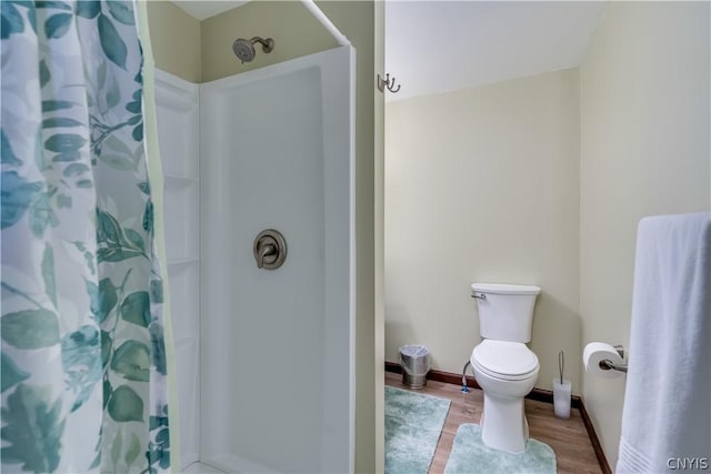 bathroom featuring hardwood / wood-style flooring, toilet, and walk in shower