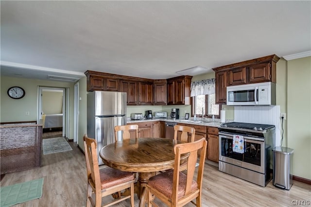 kitchen featuring sink, appliances with stainless steel finishes, and light hardwood / wood-style flooring