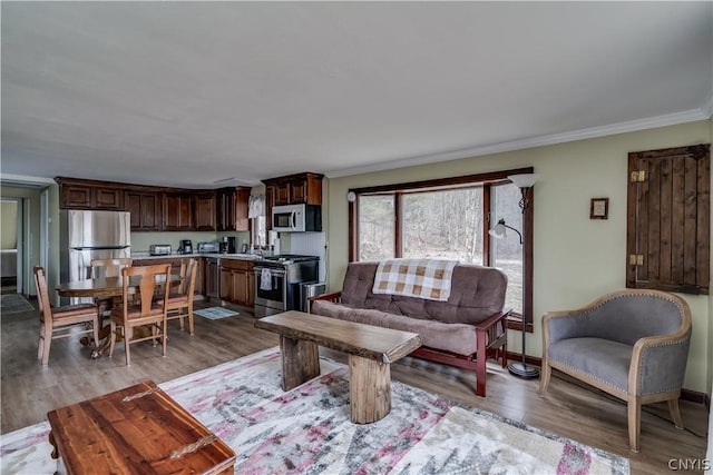 living room with crown molding and light hardwood / wood-style floors