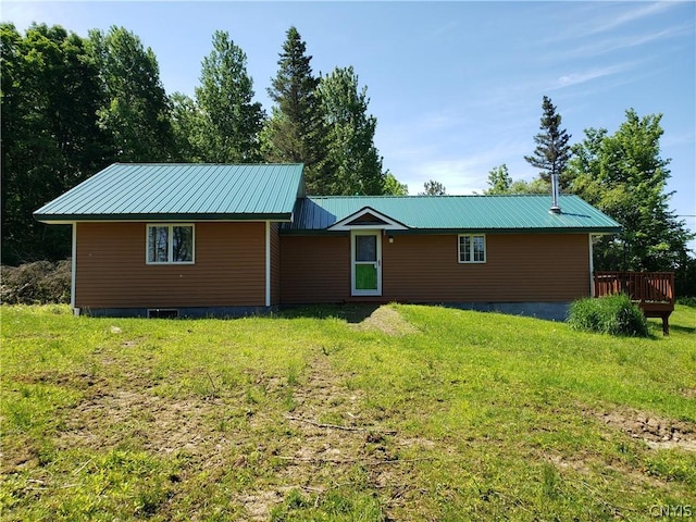 back of house featuring a wooden deck and a yard