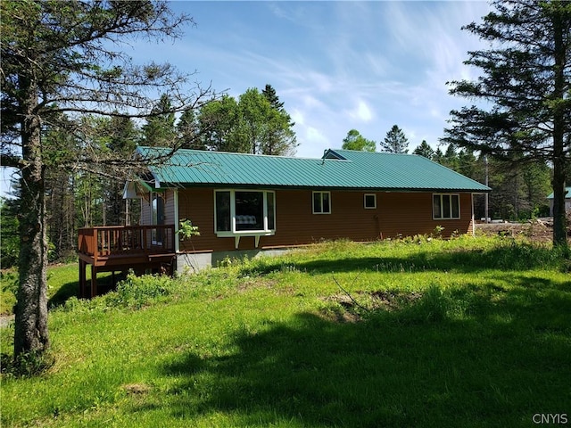 rear view of property featuring a wooden deck and a yard