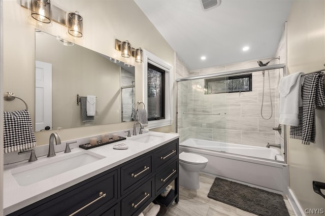 full bathroom with enclosed tub / shower combo, vaulted ceiling, vanity, and toilet