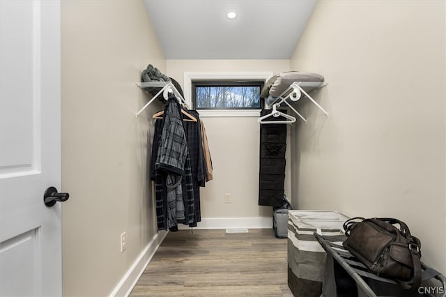 walk in closet with hardwood / wood-style floors and vaulted ceiling