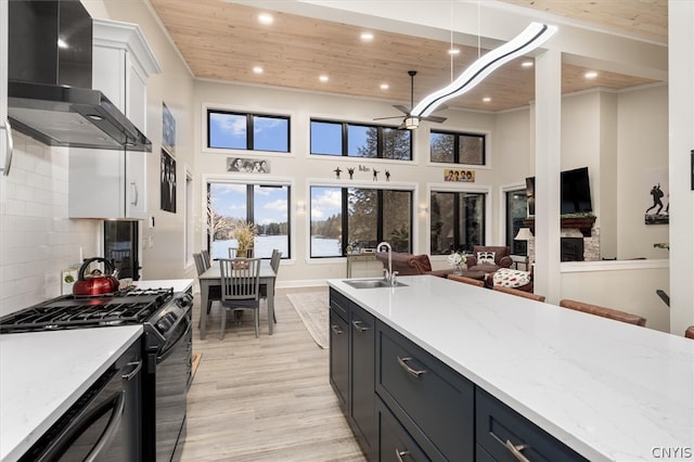 kitchen with sink, wall chimney range hood, wooden ceiling, and light hardwood / wood-style floors