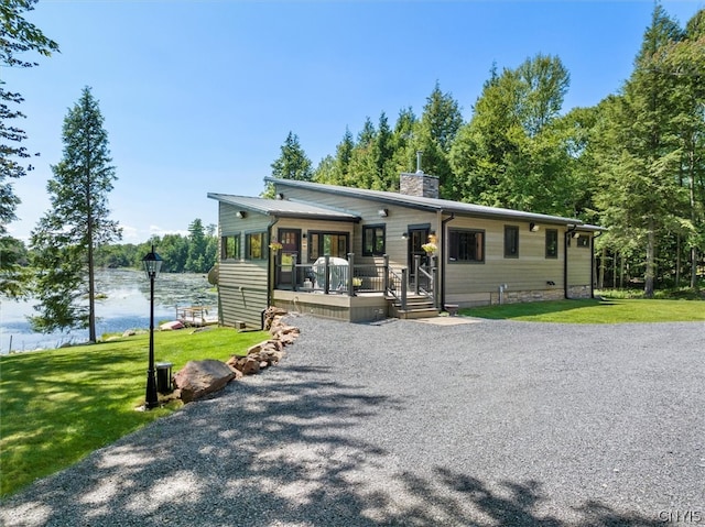 view of front facade with a water view and a front lawn