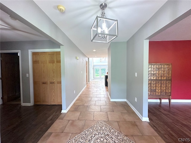 hall featuring light hardwood / wood-style floors and a notable chandelier