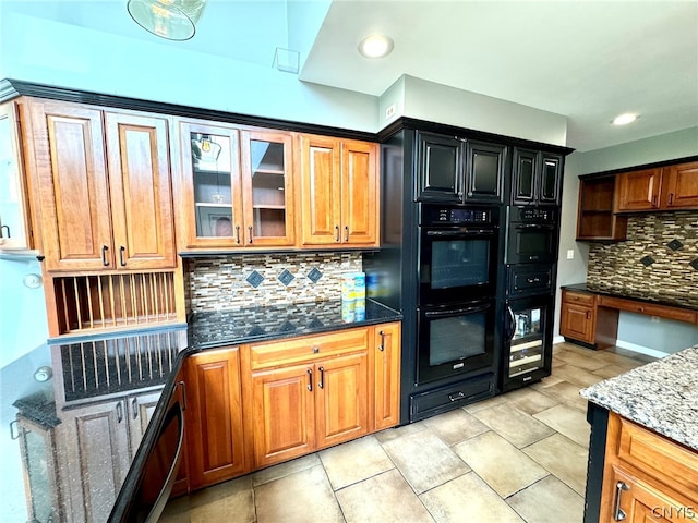 kitchen featuring stone counters, black double oven, light tile patterned floors, and backsplash