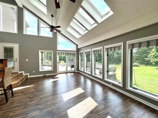 unfurnished sunroom featuring lofted ceiling with skylight, a wealth of natural light, and ceiling fan