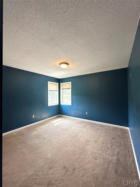 unfurnished room featuring carpet flooring and a textured ceiling