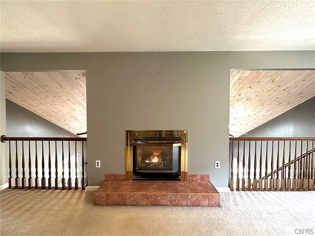 interior details featuring a tiled fireplace, carpet, and wood ceiling