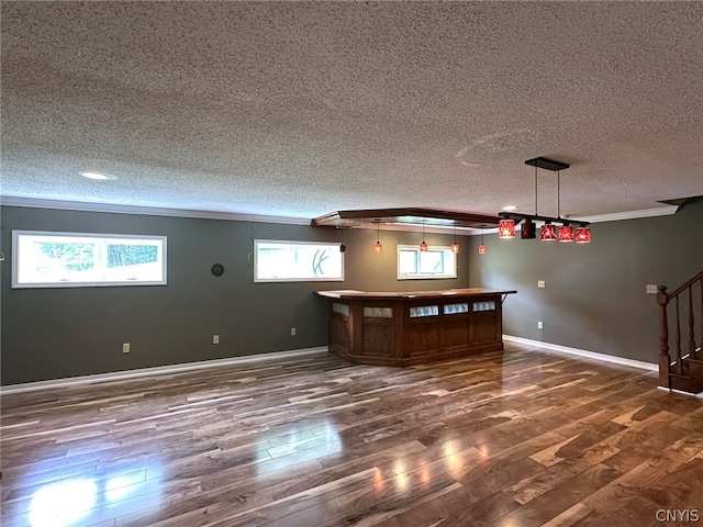 unfurnished living room with a textured ceiling, hardwood / wood-style flooring, and plenty of natural light