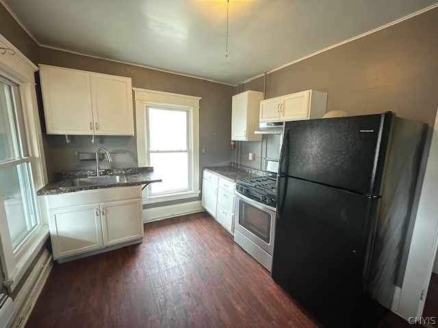 kitchen with gas stove, dark hardwood / wood-style flooring, black fridge, and white cabinetry