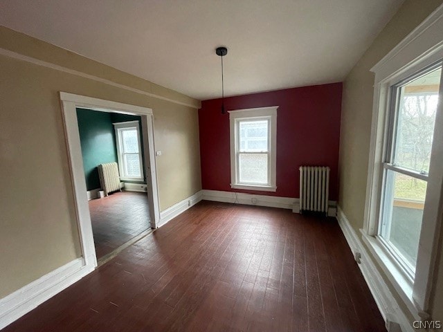 unfurnished dining area featuring dark hardwood / wood-style floors and radiator