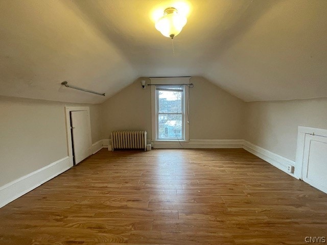 bonus room featuring hardwood / wood-style flooring, lofted ceiling, and radiator heating unit