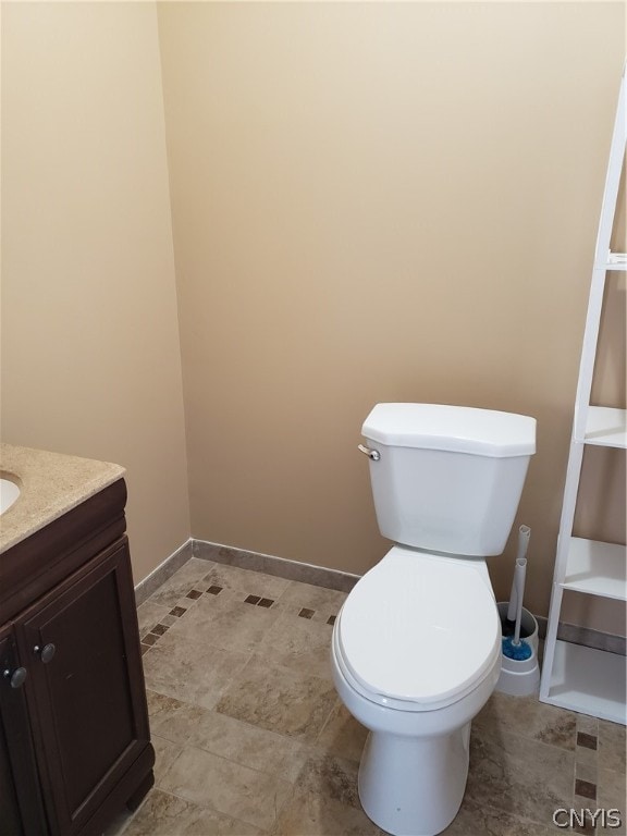 bathroom featuring vanity, tile floors, and toilet