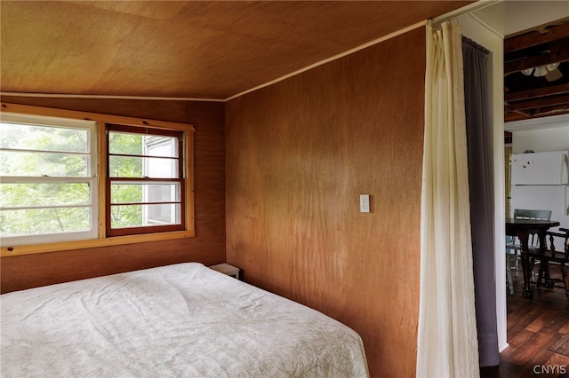 bedroom featuring dark hardwood / wood-style floors, lofted ceiling, and ornamental molding