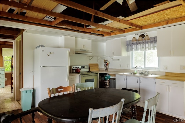 kitchen with white refrigerator, white cabinetry, a wealth of natural light, and range with electric stovetop