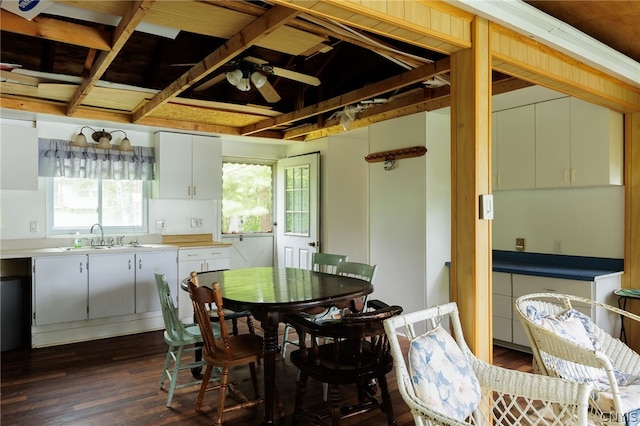 dining area featuring sink, coffered ceiling, a wealth of natural light, and dark hardwood / wood-style floors