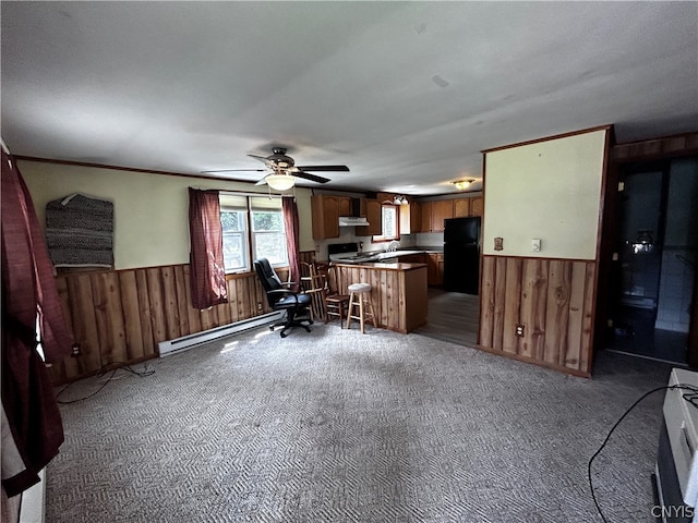 interior space with a kitchen breakfast bar, kitchen peninsula, range, black refrigerator, and carpet