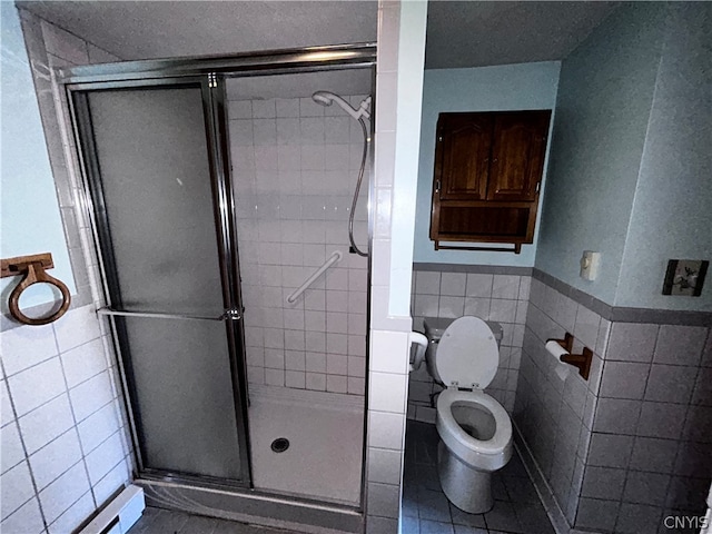 bathroom with tile flooring, an enclosed shower, tile walls, and toilet