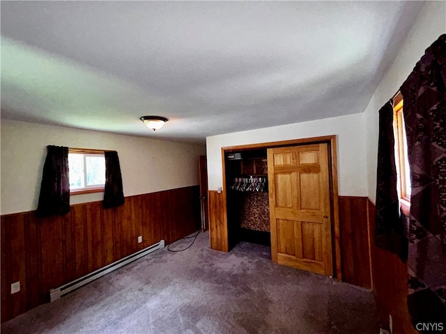 unfurnished bedroom with a baseboard radiator, a closet, and carpet