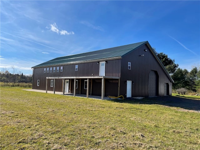 rear view of property featuring a lawn and an outdoor structure