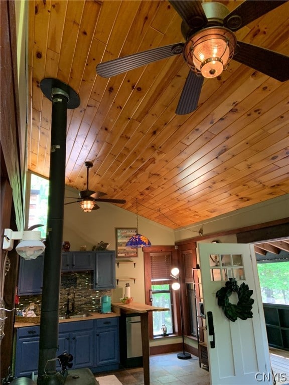 kitchen featuring a healthy amount of sunlight, backsplash, lofted ceiling, and light tile floors