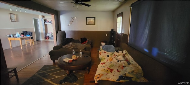 living room featuring ceiling fan and dark wood-type flooring