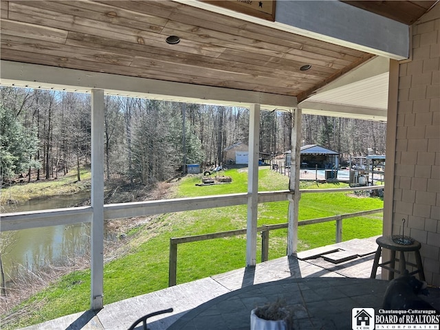 sunroom with wood ceiling, vaulted ceiling, and a water view