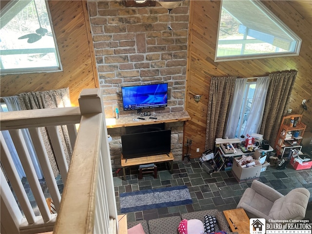 living room featuring wood walls, plenty of natural light, brick wall, and tile patterned floors