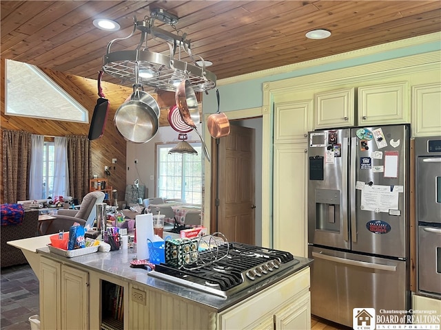 kitchen featuring appliances with stainless steel finishes, cream cabinets, tile patterned flooring, a kitchen island, and wood ceiling