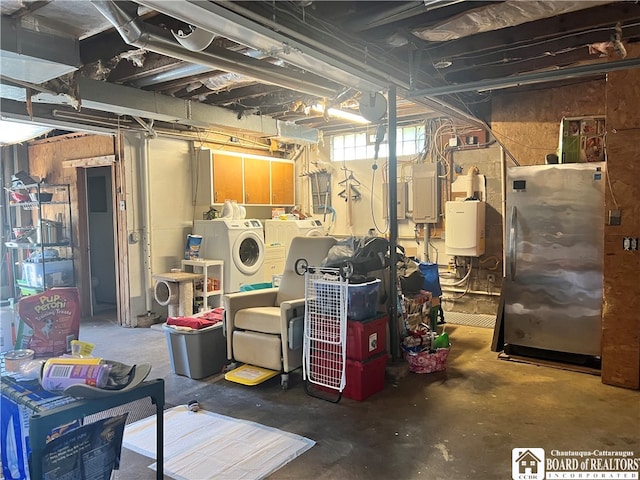 below grade area featuring electric panel, separate washer and dryer, and freestanding refrigerator