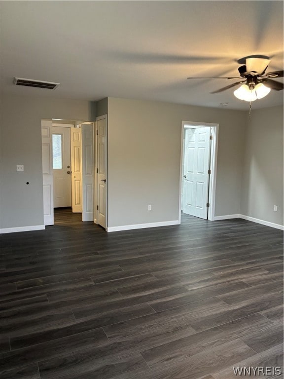 empty room with ceiling fan and dark hardwood / wood-style floors