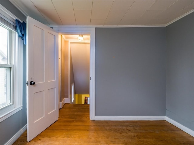 unfurnished room featuring light hardwood / wood-style flooring, a healthy amount of sunlight, and crown molding