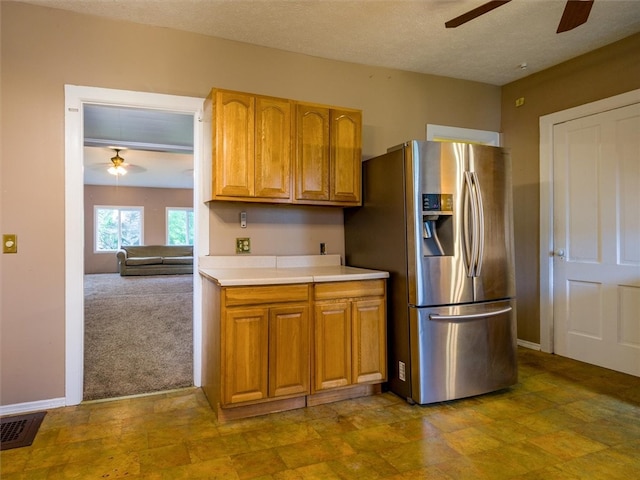 kitchen with stainless steel fridge with ice dispenser, carpet flooring, ceiling fan, and a textured ceiling