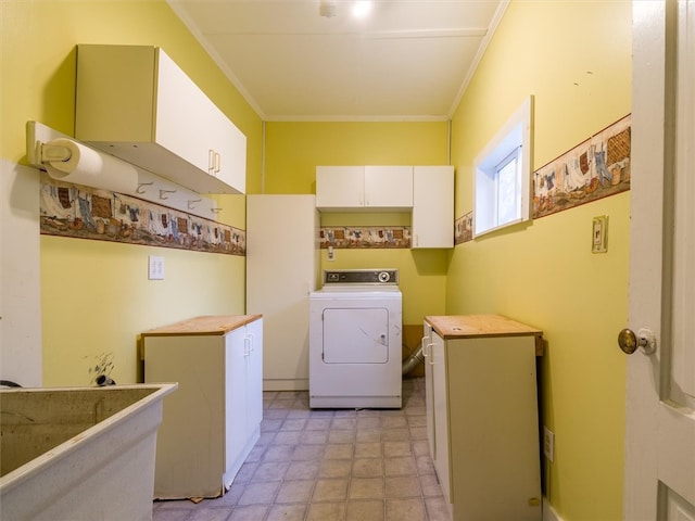 laundry area featuring crown molding, washer / clothes dryer, cabinets, and light tile floors