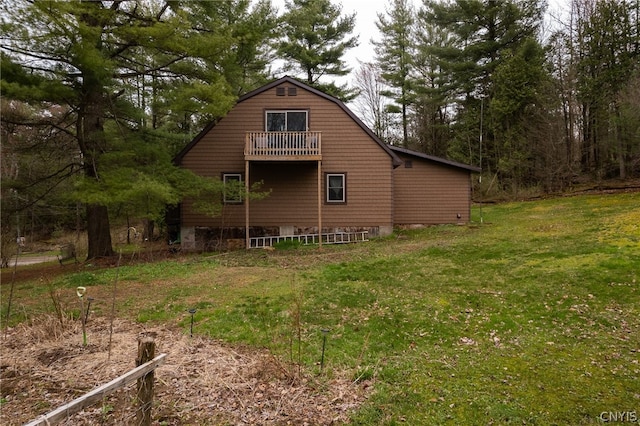 back of house with a balcony and a lawn