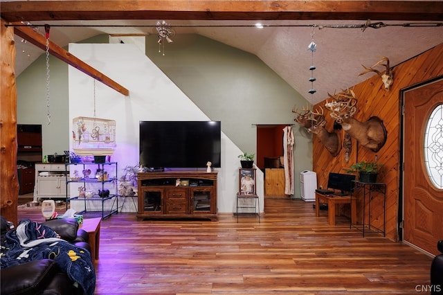 living room featuring lofted ceiling with beams, hardwood / wood-style flooring, and wooden walls