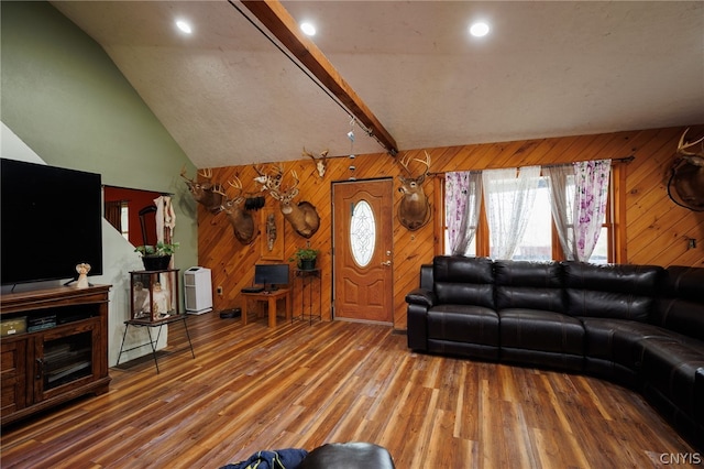 living room featuring wooden walls, wood-type flooring, and vaulted ceiling with beams