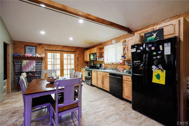 kitchen featuring wood walls, light tile flooring, vaulted ceiling with beams, black appliances, and sink