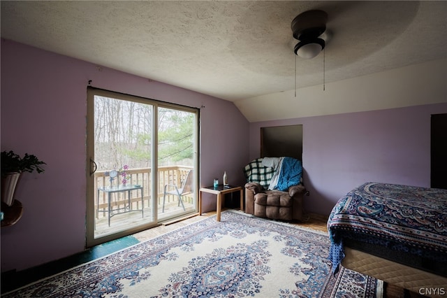 bedroom with a textured ceiling, ceiling fan, access to exterior, and lofted ceiling