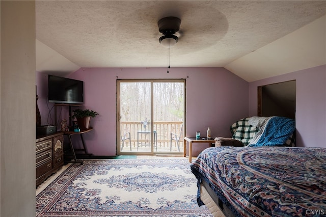 bedroom featuring lofted ceiling, ceiling fan, access to exterior, and a textured ceiling