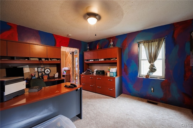 home office with light carpet, ceiling fan, and a textured ceiling