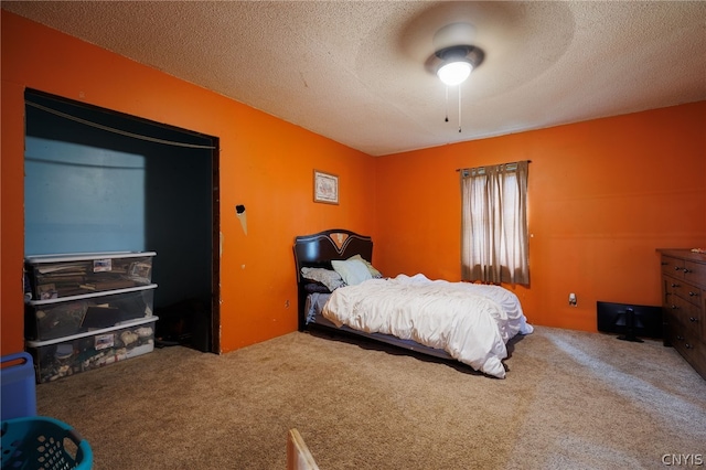 carpeted bedroom featuring ceiling fan and a textured ceiling