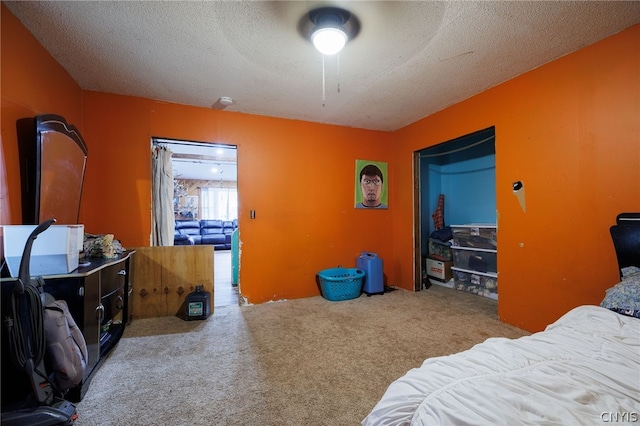 bedroom featuring a textured ceiling, ceiling fan, and light carpet